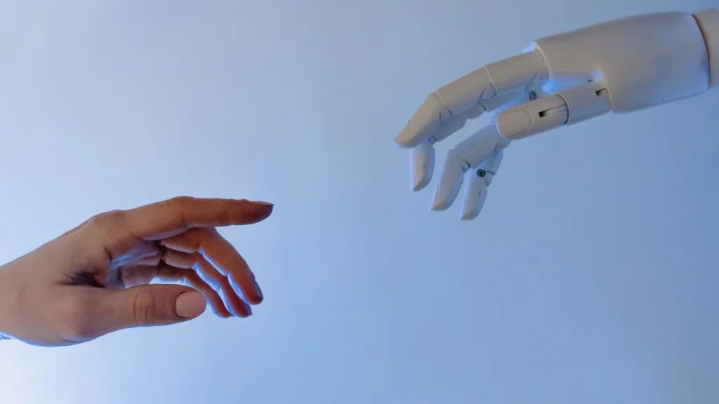 mano humana y mano robótica simbolizando la integración de inteligencia artificial en la consultoría de empresa familiar